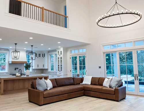 beautiful custom living room with high ceilings and custom lighting design and built by landry & co